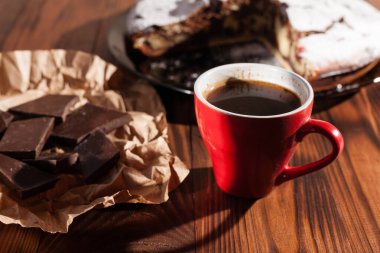 Tahta bir masada çikolatalı kahve ve pasta tatlısı..