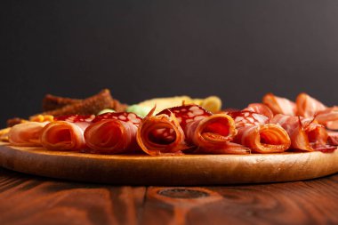 Kopya alanı olan ahşap bir masada çeşitli bira aperatifleri. Sosis, jambon, pastırma. Tuzlu abur cubur, kızarmış ekmek, fıstık, wasabi fındığı..