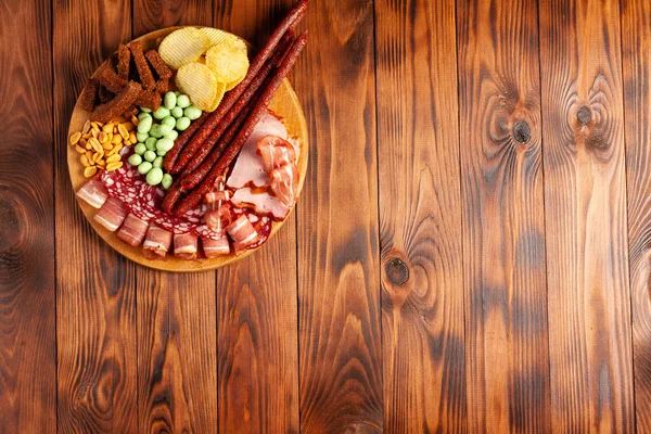 在带有复制空间的木制桌子上对啤酒小吃进行分类 咸味零食片 芥末坚果 — 图库照片