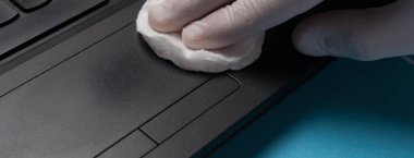 Bilgisayarı beyaz eldivenlerle temizleyen dezenfeksiyona yakın çekim. Koronavirüs enfeksiyonunun önlenmesi.