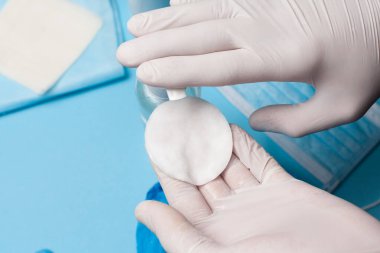 Dezenfeksiyona yakın çekim, beyaz eldivenli pamuk bloknotta antibakteriyel madde kullanımı. Koronavirüs enfeksiyonunun önlenmesi.