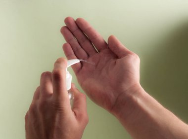 El dezenfektanı yakın plan. Karantina sırasında koronavirüsün önlenmesi ve hijyen ve salgın hastalık. Erkeklerin elleri yakın plan..