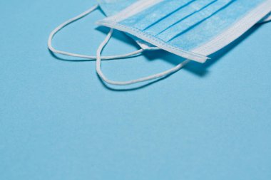 Tıbbi maske, mavi arka planda tıbbi koruyucu maske ve boş alan. Tek kullanımlık cerrahi maske. Sağlık sigortası Coronavirus, covid-19 karantina, hijyen konsepti.