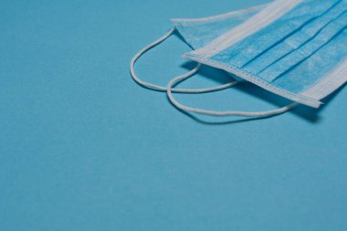 Tıbbi maske, mavi arka planda tıbbi koruyucu maske ve boş alan. Tek kullanımlık cerrahi maske. Sağlık sigortası Coronavirus, covid-19 karantina, hijyen konsepti.