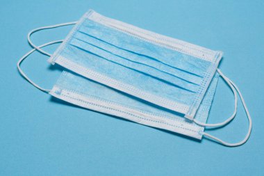 Tıbbi maske, mavi arka planda tıbbi koruyucu maske ve boş alan. Tek kullanımlık cerrahi maske. Sağlık sigortası Coronavirus, covid-19 karantina, hijyen konsepti.