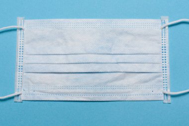 Tıbbi maske, mavi arka planda tıbbi koruyucu maske ve boş alan. Tek kullanımlık cerrahi maske. Sağlık sigortası Coronavirus, covid-19 karantina, hijyen konsepti.