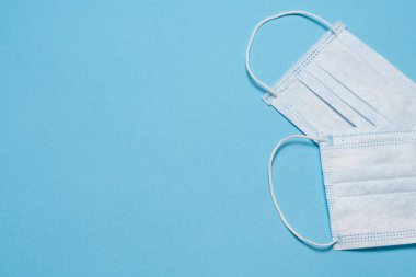 Tıbbi maske, mavi arka planda tıbbi koruyucu maske ve boş alan. Tek kullanımlık cerrahi maske. Sağlık sigortası Coronavirus, covid-19 karantina, hijyen konsepti.
