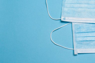 Tıbbi maske, mavi arka planda tıbbi koruyucu maske ve boş alan. Tek kullanımlık cerrahi maske. Sağlık sigortası Coronavirus, covid-19 karantina, hijyen konsepti.