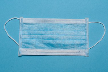 Tıbbi maske, mavi arka planda tıbbi koruyucu maske ve boş alan. Tek kullanımlık cerrahi maske. Sağlık sigortası Coronavirus, covid-19 karantina, hijyen konsepti.