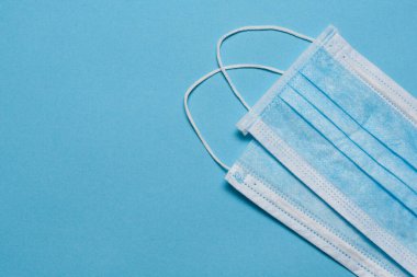 Tıbbi maske, mavi arka planda tıbbi koruyucu maske ve boş alan. Tek kullanımlık cerrahi maske. Sağlık sigortası Coronavirus, covid-19 karantina, hijyen konsepti.