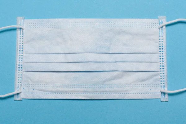 Tıbbi maske, mavi arka planda tıbbi koruyucu maske ve boş alan. Tek kullanımlık cerrahi maske. Sağlık sigortası Coronavirus, covid-19 karantina, hijyen konsepti.
