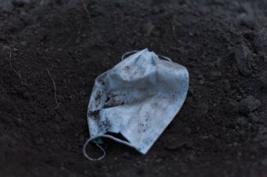 Kıyametten sonra yerde bir tıbbi maske yatıyor. Dünyanın sonu, tehdit koronavirüsü - kavram. Kimse..