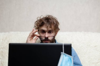 Adam dizüstü bilgisayarından haberleri izliyor. Küçük işletmelerin düşüşü. Kötü haber..