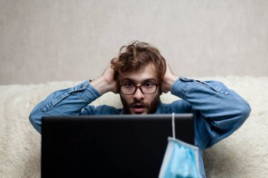 Adam dizüstü bilgisayarından haberleri izliyor. Küçük işletmelerin düşüşü. Kötü haber..