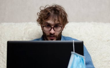 Adam dizüstü bilgisayarından haberleri izliyor. Küçük işletmelerin düşüşü. Kötü haber..