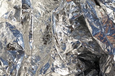 İnce, buruşmuş bir folyonun dokusu. Buruşuk folyo arka plan. Fotokopi kağıdı. Gümüş krom rengi.