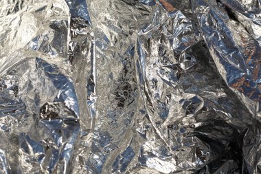 İnce, buruşmuş bir folyonun dokusu. Buruşuk folyo arka plan. Fotokopi kağıdı. Gümüş krom rengi.