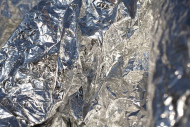 İnce, buruşmuş bir folyonun dokusu. Buruşuk folyo arka plan. Fotokopi kağıdı. Gümüş krom rengi.