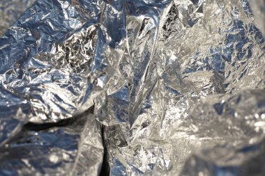 İnce, buruşmuş bir folyonun dokusu. Buruşuk folyo arka plan. Fotokopi kağıdı. Gümüş krom rengi.