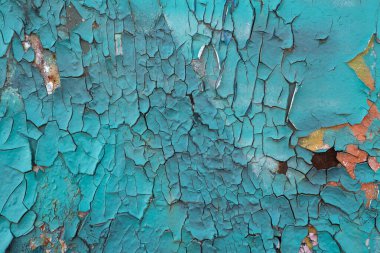 Eski boyanmış duvarın dokusu çatlaklar ve pürüzlerle kaplıdır. Çatlaklı eski bir boyanın stok fotoğrafı. Turkuaz boya..