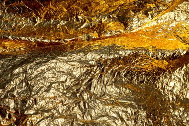 İnce, buruşmuş bir folyonun dokusu. Buruşuk folyo arka plan. Fotokopi kağıdı. Altın krom rengi.