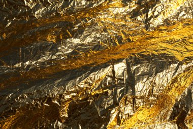 İnce, buruşmuş bir folyonun dokusu. Buruşuk folyo arka plan. Fotokopi kağıdı. Altın krom rengi.