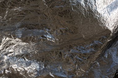 İnce, buruşmuş bir folyonun dokusu. Buruşuk folyo arka plan. Fotokopi kağıdı. Gümüş krom rengi.