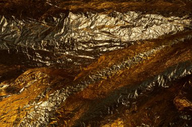 Texture of a thin crumpled sheet of foil. Crumpled foil background. Stock photo foil. Gold chrome color. clipart