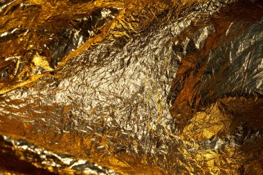 İnce, buruşmuş bir folyonun dokusu. Buruşuk folyo arka plan. Fotokopi kağıdı. Altın krom rengi.