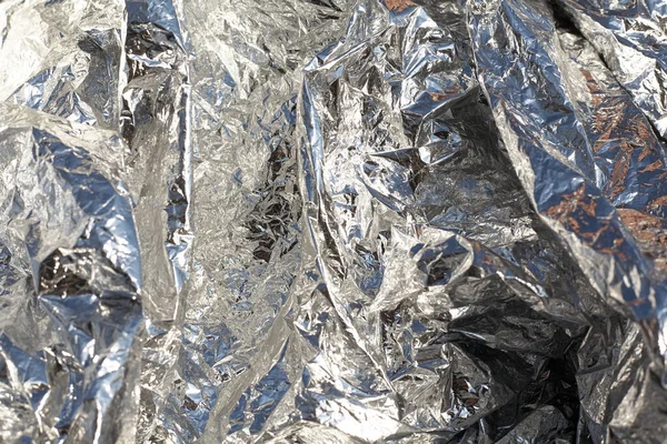 Texture of a thin crumpled sheet of foil. Crumpled foil background. Stock photo foil. Silver chrome color.