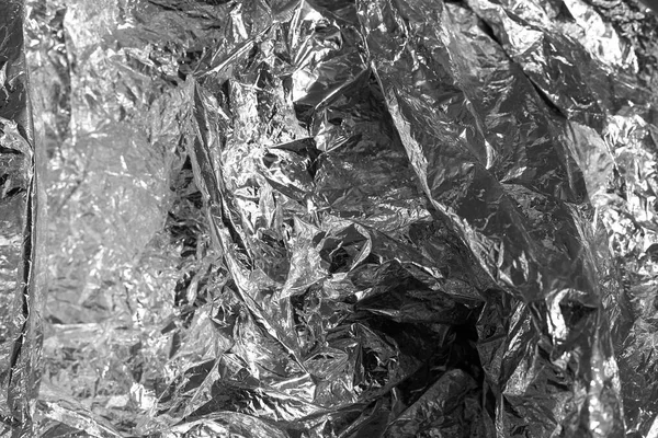 Texture of a thin crumpled sheet of foil. Crumpled foil background. Stock photo foil. Silver chrome color.