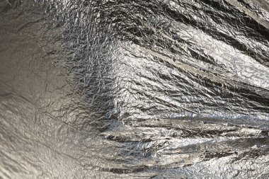 İnce, buruşmuş bir folyonun dokusu. Buruşuk folyo arka plan. Fotokopi kağıdı. Gümüş krom rengi.