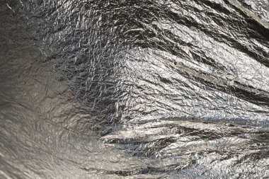 İnce, buruşmuş bir folyonun dokusu. Buruşuk folyo arka plan. Fotokopi kağıdı. Gümüş krom rengi.