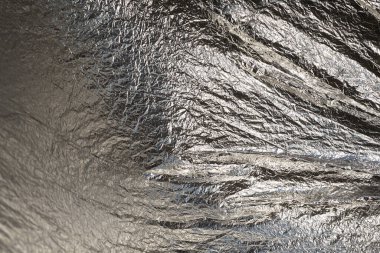 İnce, buruşmuş bir folyonun dokusu. Buruşuk folyo arka plan. Fotokopi kağıdı. Gümüş krom rengi.