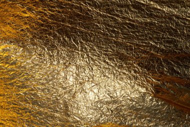 İnce, buruşmuş bir folyonun dokusu. Buruşuk folyo arka plan. Fotokopi kağıdı. Altın krom rengi.