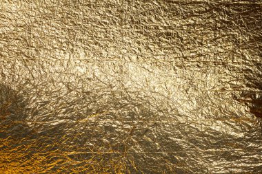 İnce, buruşmuş bir folyonun dokusu. Buruşuk folyo arka plan. Fotokopi kağıdı. Altın krom rengi.
