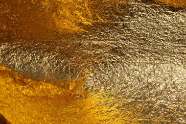 İnce, buruşmuş bir folyonun dokusu. Buruşuk folyo arka plan. Fotokopi kağıdı. Altın krom rengi.