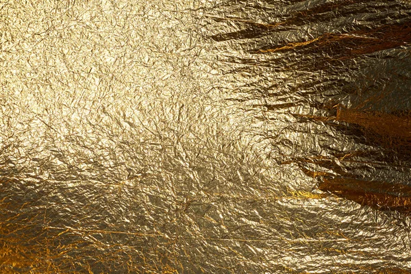 Texture of a thin crumpled sheet of foil. Crumpled foil background. Stock photo foil. Gold chrome color.