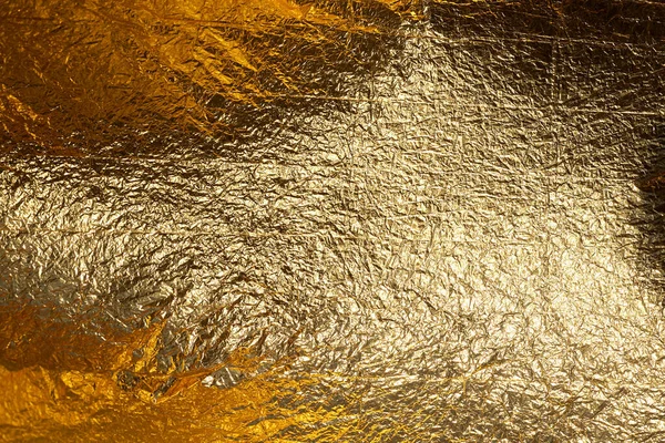 Texture of a thin crumpled sheet of foil. Crumpled foil background. Stock photo foil. Gold chrome color.