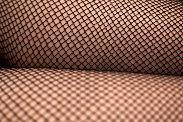 漂亮的女性腿穿着网眼紧身衣 时髦的黑色网眼紧身衣和一个年轻女孩性感的脚镣 — 图库照片