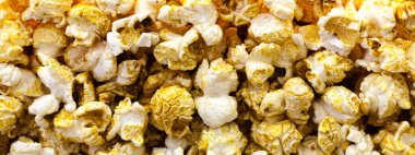 Patlamış mısır arka planı yakın plan. Camın arkasındaki sinemada çeşitli patlamış mısırlar. Patlamış mısır dokusu.