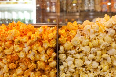 Patlamış mısır arka planı yakın plan. Camın arkasındaki sinemada çeşitli patlamış mısırlar. Patlamış mısır dokusu.