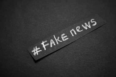 Sahte haber. İsim beyaz tebeşirle siyah bir arkaplanda kağıt şeklinde yazılır..