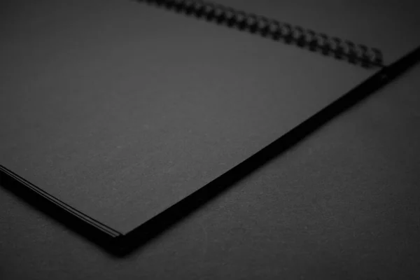 黒いテーブルの上に空白の黒いノートブック モックアップ写真 デザインのためのコピースペースとブランクブラックカバーテンプレート 黒に黒 最小限のデザインコンセプト — ストック写真