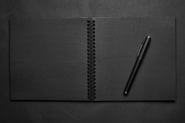 黒いテーブルの上に空白の黒いノートブック モックアップ写真 デザインのためのコピースペースとブランクブラックカバーテンプレート 黒に黒 最小限のデザインコンセプト — ストック写真