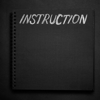 Kullanım kılavuzu boş boşluklu bir not defterine yazılmış. Boş siyah not defteri arkaplanı.