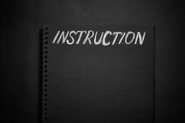 Kullanım kılavuzu boş boşluklu bir not defterine yazılmış. Boş siyah not defteri arkaplanı.