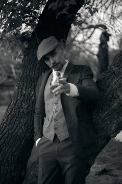 1920 'lerden kalma düz şapkalı bir İngiliz gangsterin portresi. Sokakta sigara içiyor...