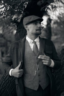 1920 'lerden kalma düz şapkalı bir İngiliz gangsterin portresi. Sokakta sigara içiyor...