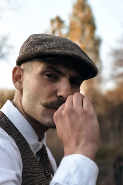 20世纪20年代的肖像画一个戴着平顶帽子的英国匪帮 在街上抽烟 — 图库照片